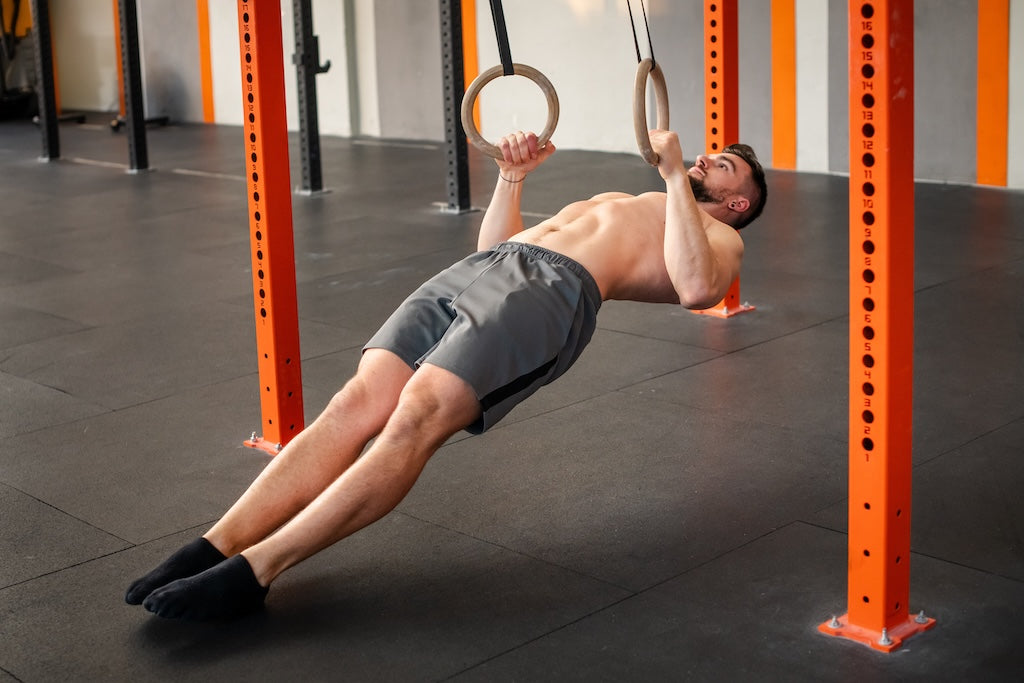 Mann führt Ring Row Übung aus - gezieltes Zug-Training für den Rücken